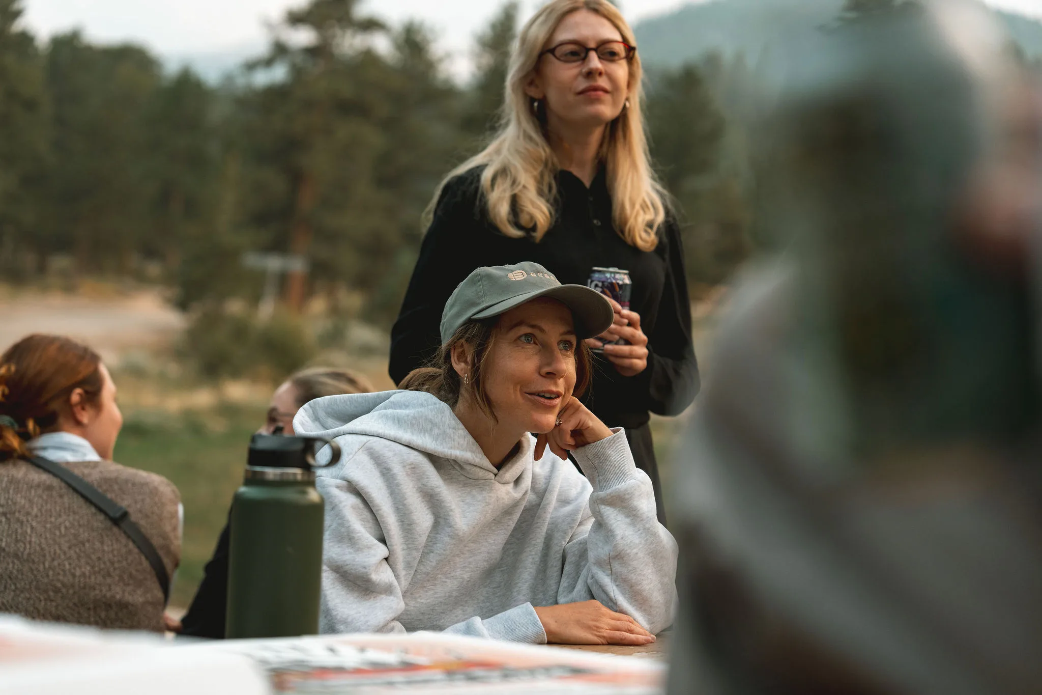 Two women sitting at a table outside talking