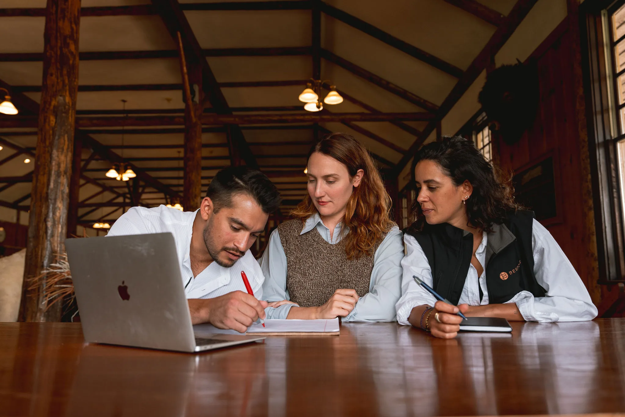 Three people sitting around a table brainstorming